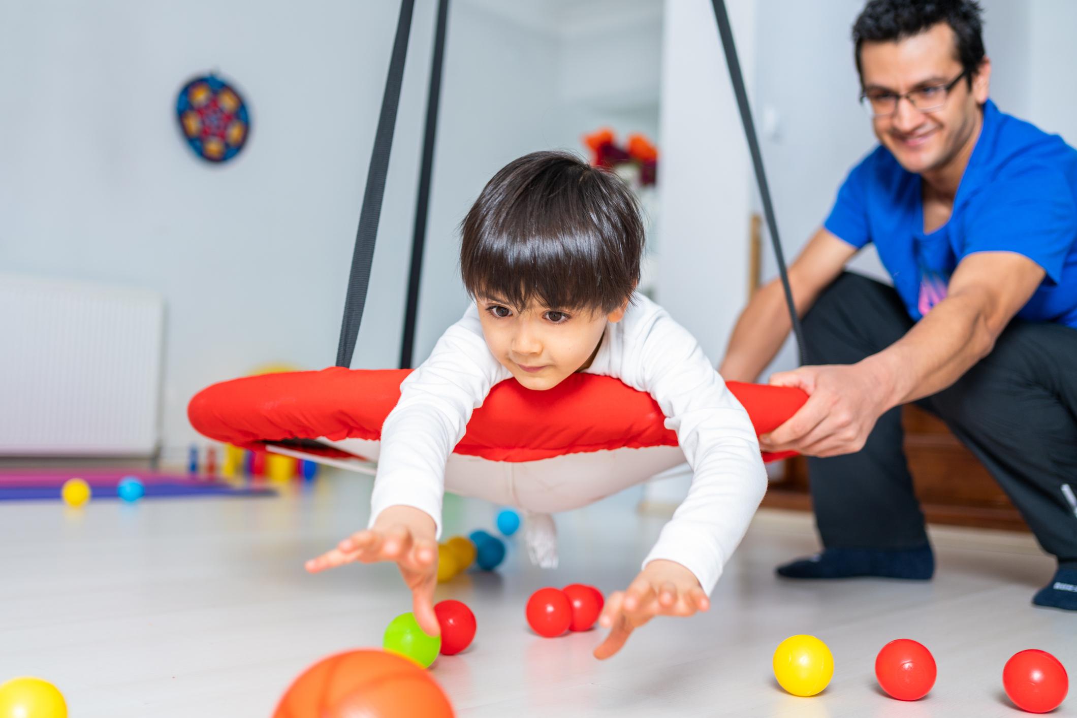 child playing with toys observed by therapist